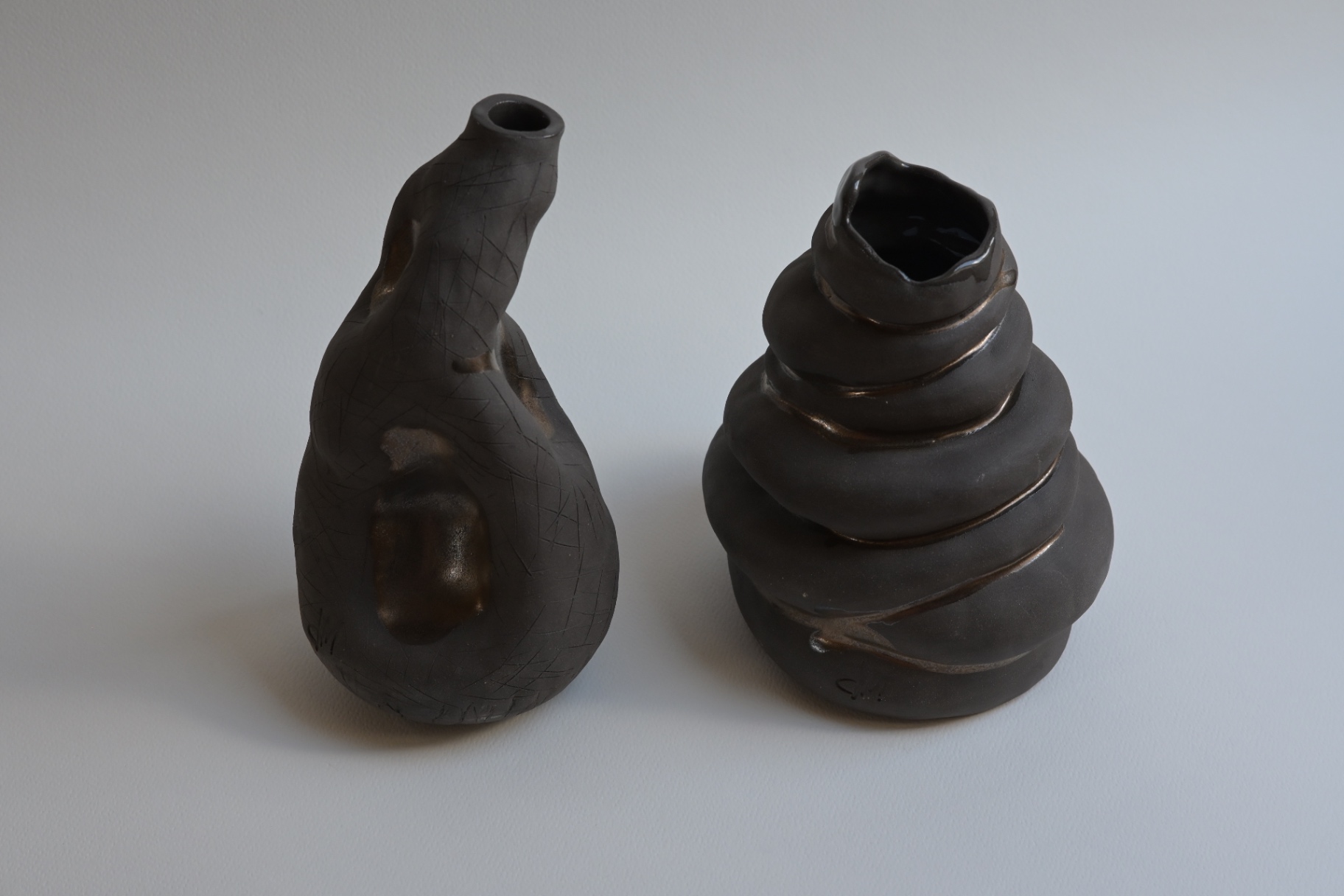 Counterforms, two dark ceramic bodies moving in opposite directions