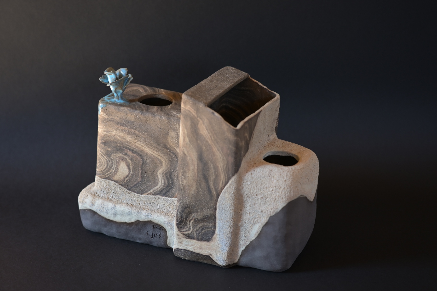Inhabited Ground, marbled planes rising to shelter a small blue bloom