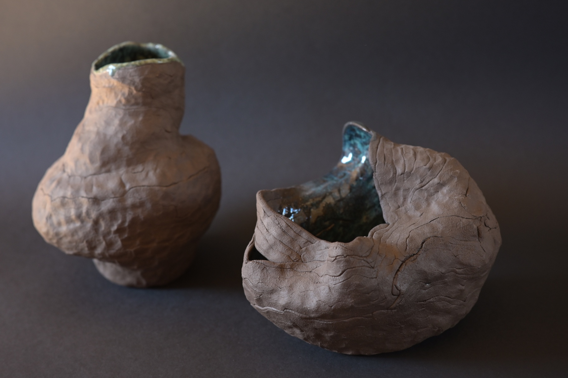 Inner Weather, two dark ceramic forms with blue-green glazed interiors
