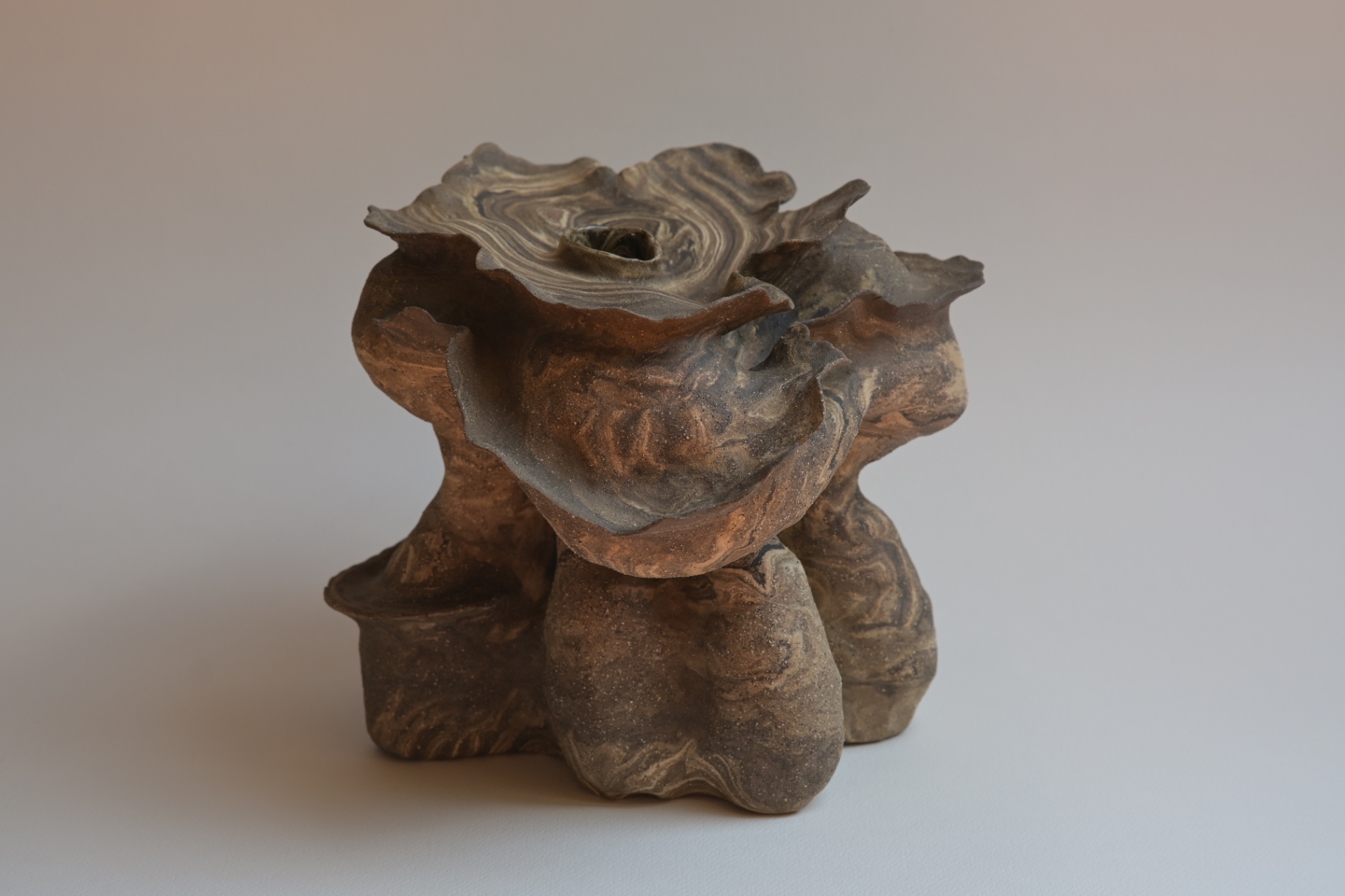 Haven, marbled planes unfolding around a compact body with a green inclusion