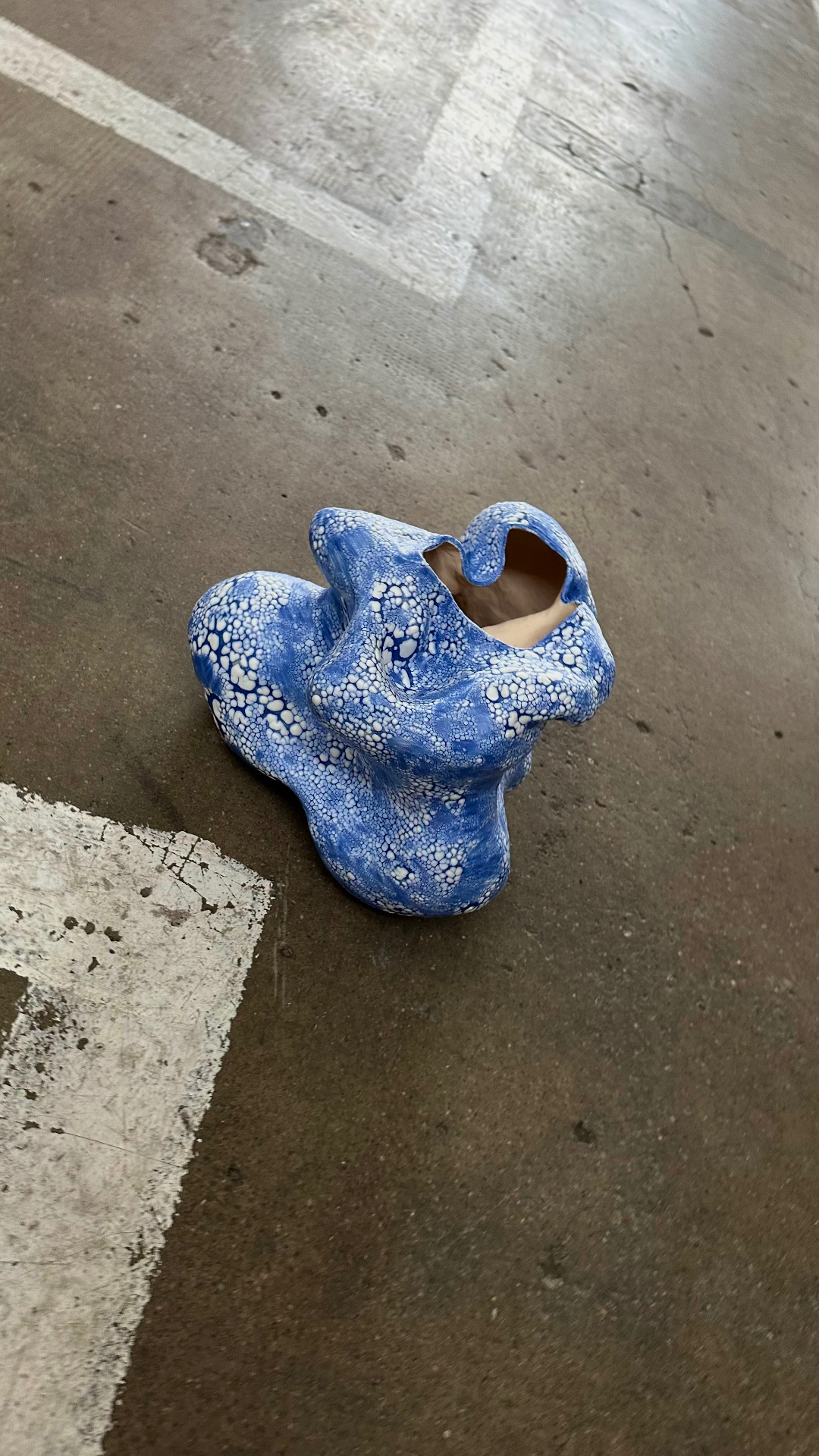 Blue crackle-glazed ceramic form on concrete floor, Mushuroi 2023